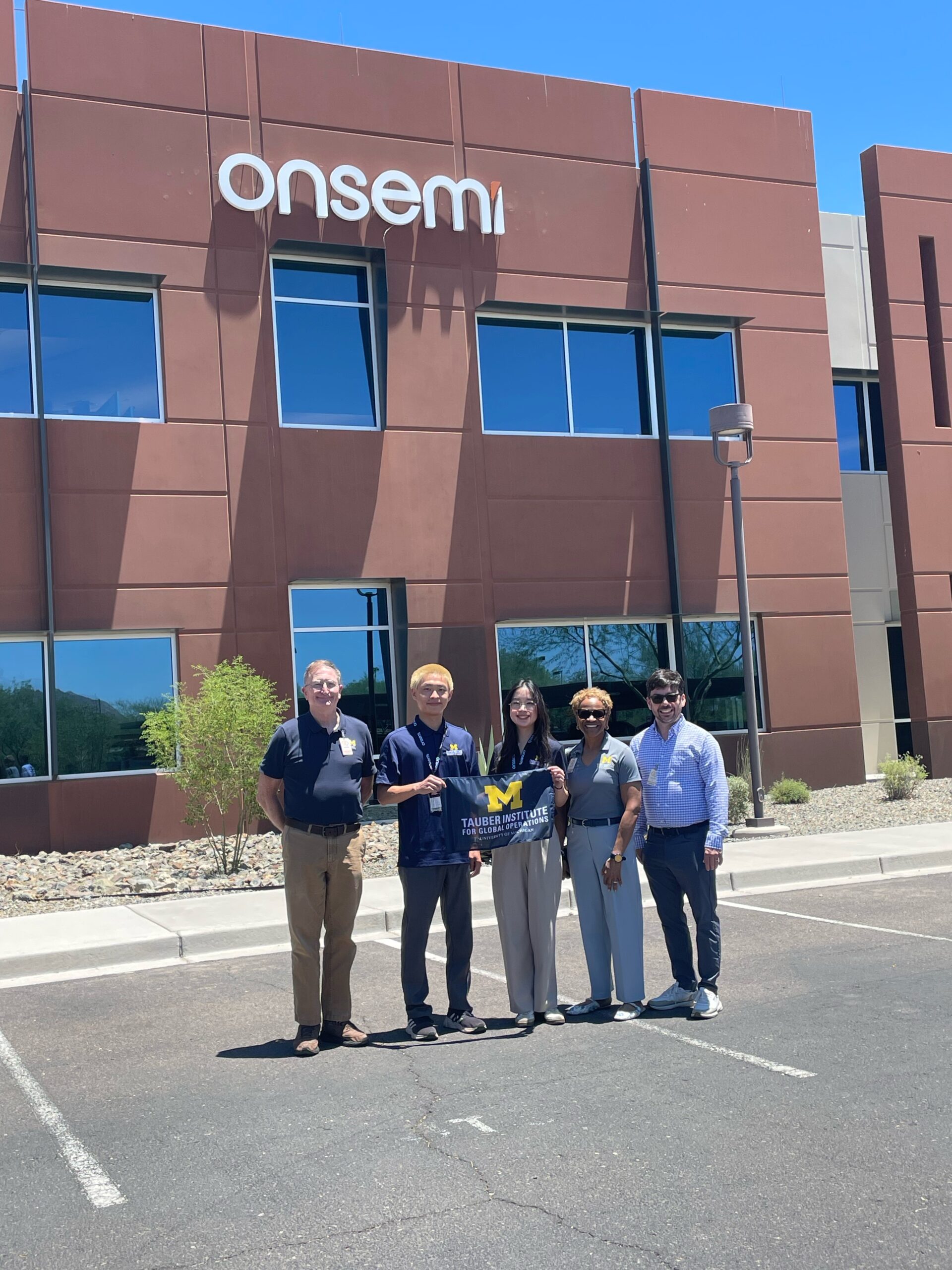 A group of people posing in front of Onsemi's building