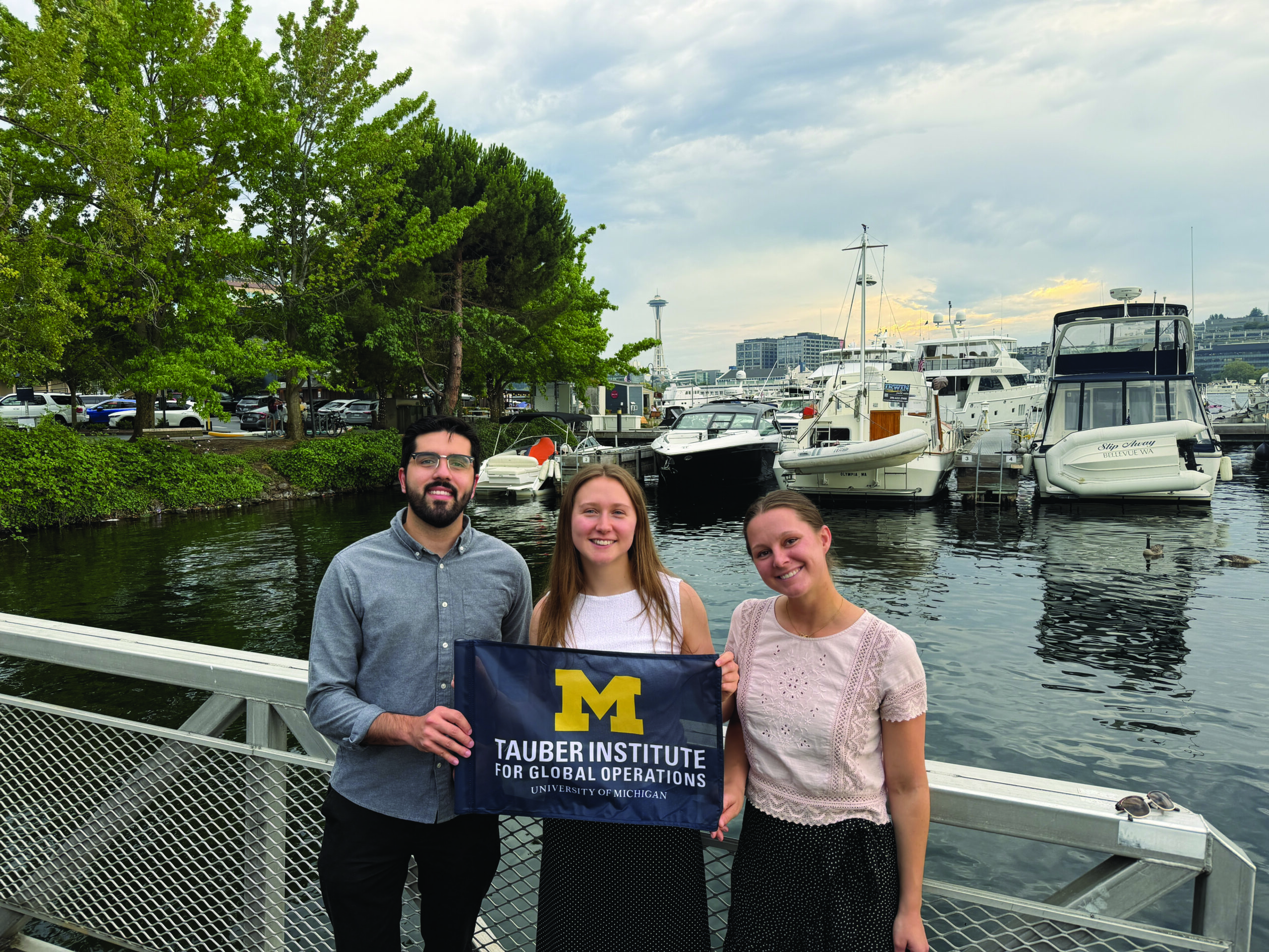 Boeing team 2026 pose by a marina holding a Tauber flag