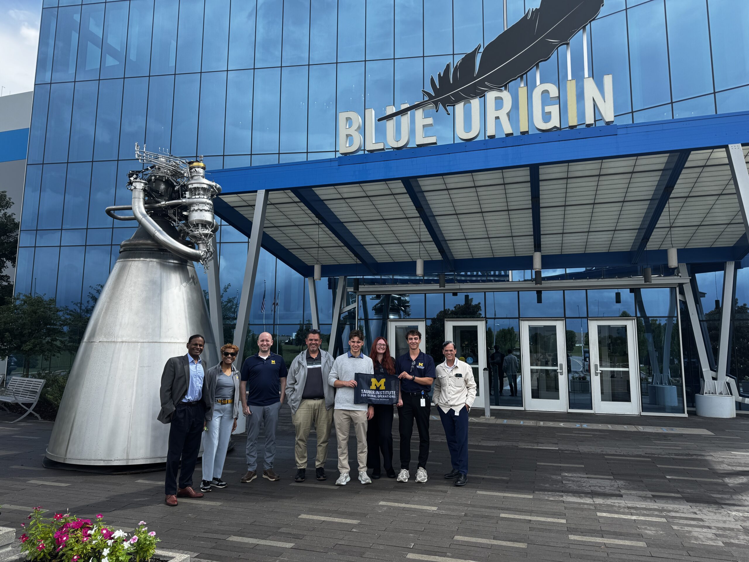 A group of students pose in front of the blue origin building
