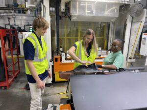 Two students working in a factory