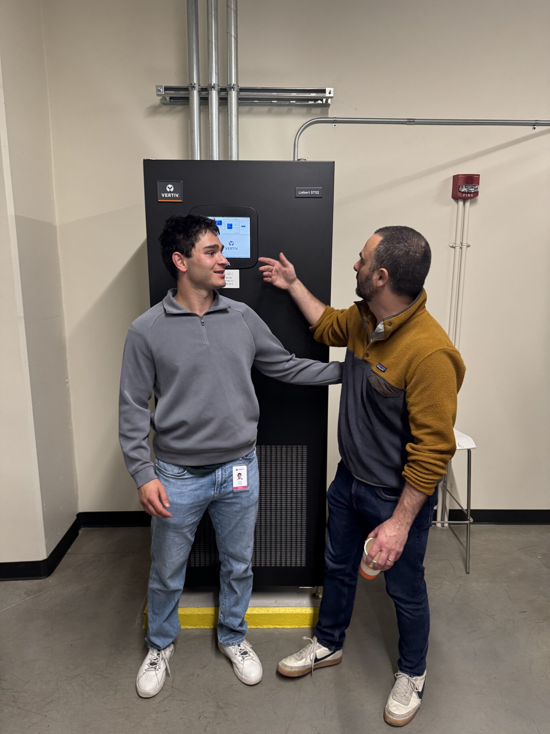 Two students pose with the data center machine they worked on