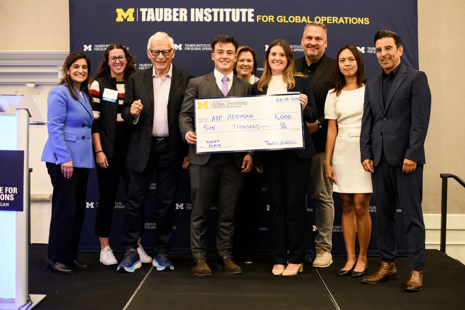2024 Spotlight! third-place winners from American Industrial Partners -- ADDMAN pose with their check
